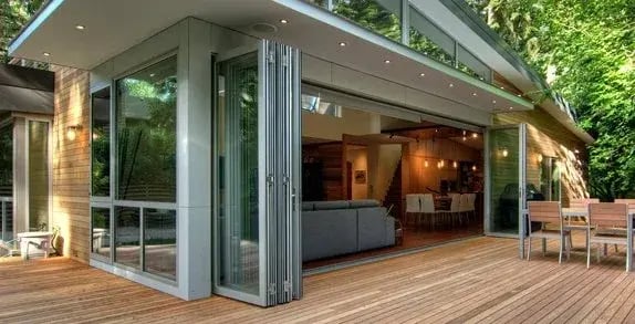 Folding glass doors opening a kitchen onto a wood deck