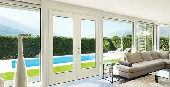 White-framed glass patio doors overlooking a swimming pool