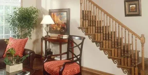 Wood staircase with turned balusters beside a sitting area