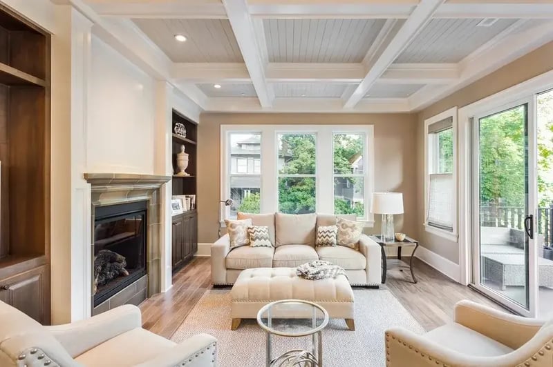 Living room with a coffered ceiling, fireplace, and tall windows