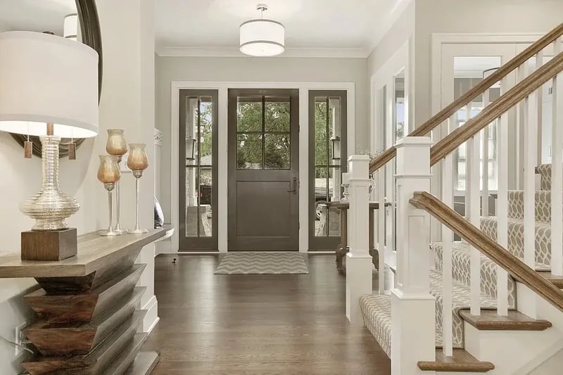 Entry hall with a glass-panel front door, sidelights, and wood staircase