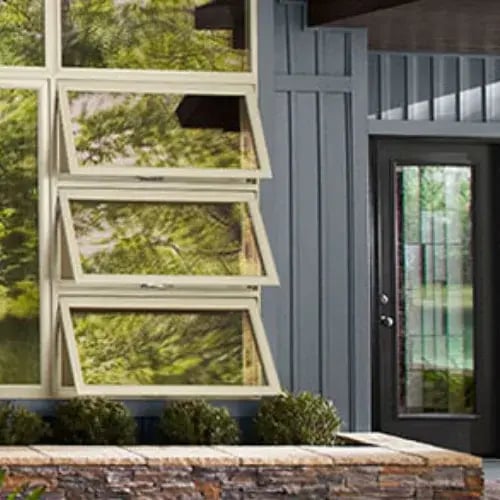 Stacked awning windows beside a glass entry door